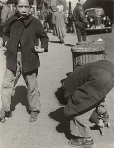 105th Street - Two boys playing with roller skates, each wearing a single roller..., 1947 - 1951. Creator: Romulo Lachatanere