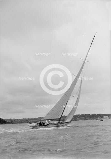 12 Metre class sailing yacht heeling over in windy conditions on upwind leg, 1938. Creator: Kirk & Sons of Cowes.