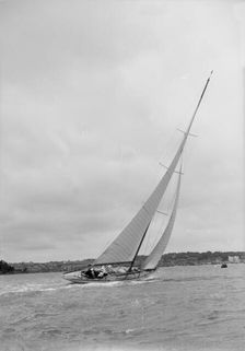 12 Metre class sailing yacht heeling over in windy conditions on upwind leg, 1938. Creator: Kirk & Sons of Cowes