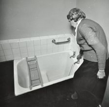 16 Candy Street, Poplar, London: elderly woman in bathroom, 1962. Creator: Unknown