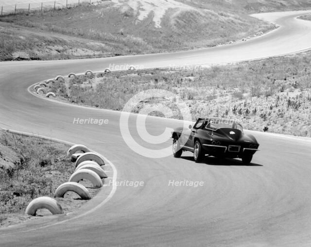 1964 Chevrolet Corvette Stingray on a winding racetrack, (c1964?). Artist: Unknown