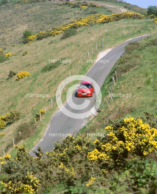 1996 Suzuki Baleno GS Sport on winding country lane,Dorset. Artist: Unknown.