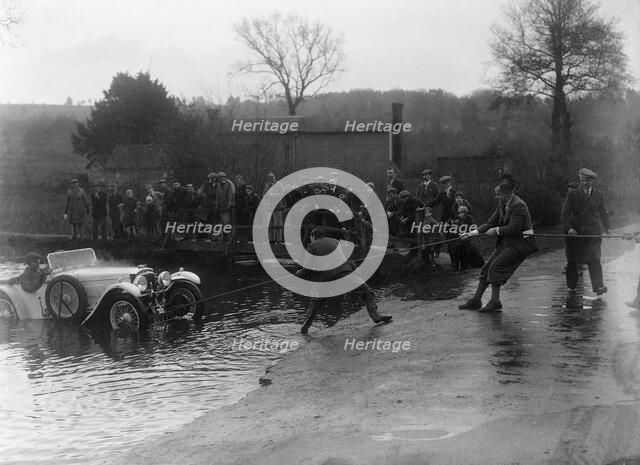 1935 Frazer-Nash TT replica being pulled out of a ford during a motoring trial, 1936. Artist: Bill Brunell.