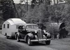 1936 Oldsmobile Eight with caravan in Scotland. Creator: Unknown