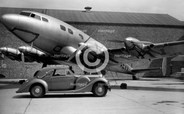 1938 Lagonda V12 4.5 litre drophead coupe with D.H. Albatross aeroplane Artist: Unknown.