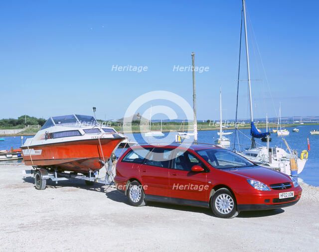 2002 Citroen C5 hdi towing a boat by harbour. Artist: Unknown.