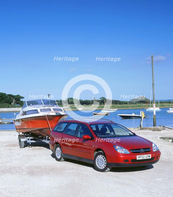 2002 Citroen C5 hdi towing a boat by harbour. Artist: Unknown.