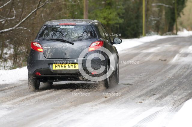 2009 Mazda 2 driving on snowy road Artist: Unknown.