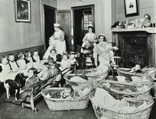 30 Albury Street; Nursey at dinner time, Children in Baskets, 1911. Creator: Unknown