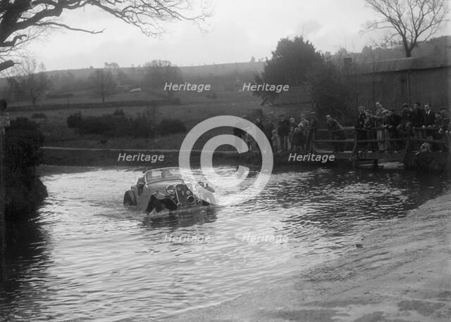972 cc Singer Le Mans driving through a ford during a motoring trial, 1936. Artist: Bill Brunell.