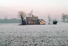 Cottage in a snowy field, Eye, Suffolk. Creator: Tony Evans