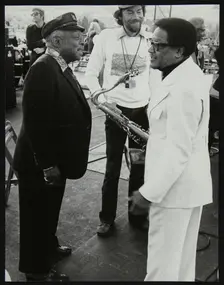 Count Basie chatting with Illinois Jacquet at the Capital Radio Jazz Festival, London, July 1979. Creator: Denis Williams