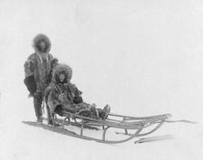 Couple on dog sled, between c1900 and 1927. Creator: Lomen Brothers