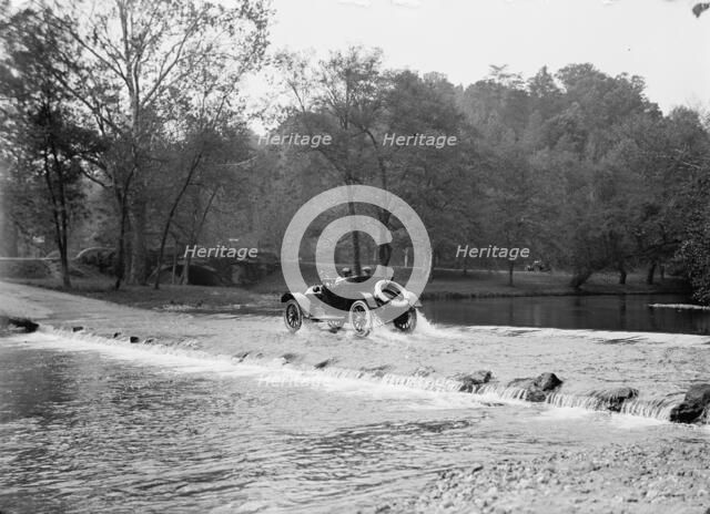 Couple In Automobile Fording A River At A Low Water Crossing Near A Small Stone Bridge, ca.1913-1918 Creator: Harris & Ewing.