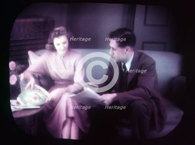 Couple sitting on sofa within TV screen, c1955. Creator: Arthur Charles Kirby Ware.
