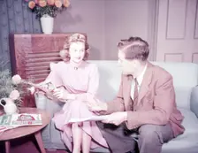 Couple sitting on sofa, c1955. Creator: Arthur Charles Kirby Ware