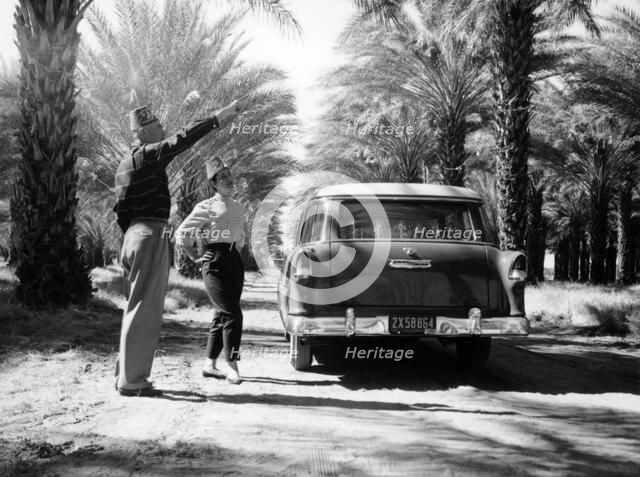 Couple with a 1955 Chevrolet Townsman station wagon, (c1955?). Artist: Unknown