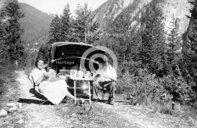 Couple with Vauxhall Wyvern enjoying a picnic, c1950. Artist: Unknown