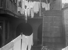 Courtyard with cistern and hanging laundry, New Orleans, between 1920 and 1926. Creator: Arnold Genthe