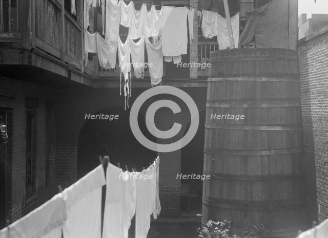 Courtyard with cistern and hanging laundry, New Orleans, between 1920 and 1926. Creator: Arnold Genthe.