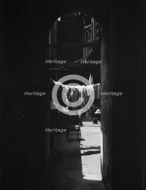 Courtyard with hanging laundry, New Orleans, between 1920 and 1926. Creator: Arnold Genthe.