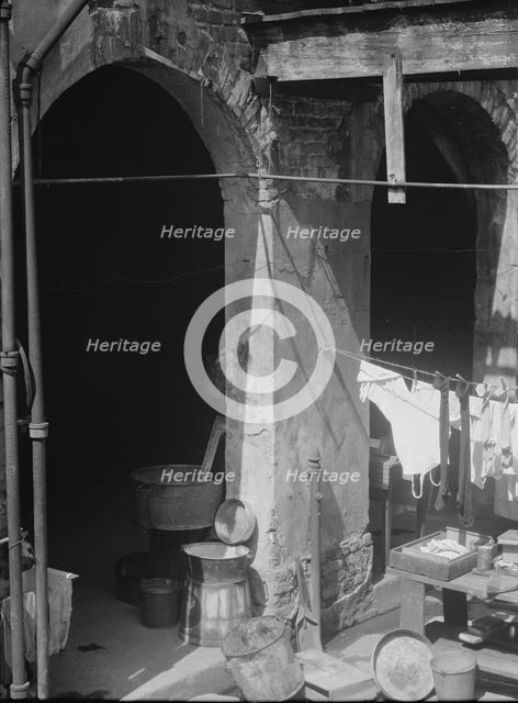 Courtyard with hanging laundry and laundry equipment, New Orleans, between 1920 and 1926. Creator: Arnold Genthe.
