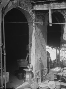 Courtyard with hanging laundry and laundry equipment, New Orleans, between 1920 and 1926. Creator: Arnold Genthe