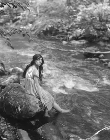 Cowan, Rosamonde, Miss (Rose Rolanda ; Mrs. Miguel C.), seated by a stream, 1919 May 24. Creator: Arnold Genthe