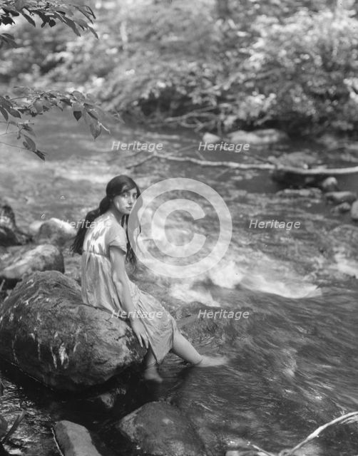 Cowan, Rosamonde, Miss (Rose Rolanda ; Mrs. Miguel C.), seated by a stream, 1919 May 24. Creator: Arnold Genthe.