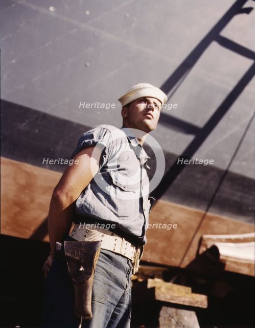 Coast Guardsman standing watch over 78-foot torpedo..., Higgins Industries, Inc., New Orleans, 1942. Creator: Howard Hollem.