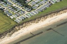 Coastal erosion between a caravan park and the sea defences at Corton Cliffs, Suffolk, 2019. Creator: Historic England