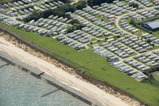 Coastal erosion between a caravan park and the sea defences at Corton Cliffs, Suffolk, 2019. Creator: Historic England