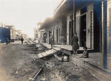 Colón, Panama: unpaved street lined with wooden houses; two children watch from a porch..., 1906. Creator: Unknown