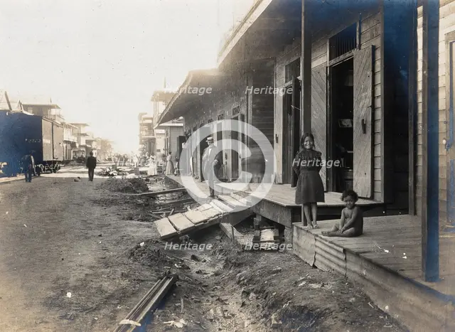 Colón, Panama: unpaved street lined with wooden houses; two children watch from a porch..., 1906. Creator: Unknown.