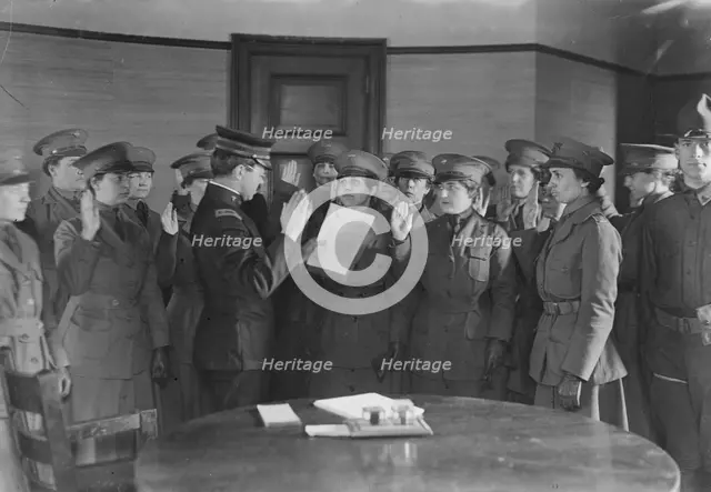 Colonel J.H. Wells swearing in woman motorist, 29 May 1917. Creator: Bain News Service.