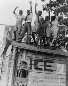 Colored boys playing on top of Coca Cola stand, Little Rock, Arkansas, 1938. Creator: Dorothea Lange