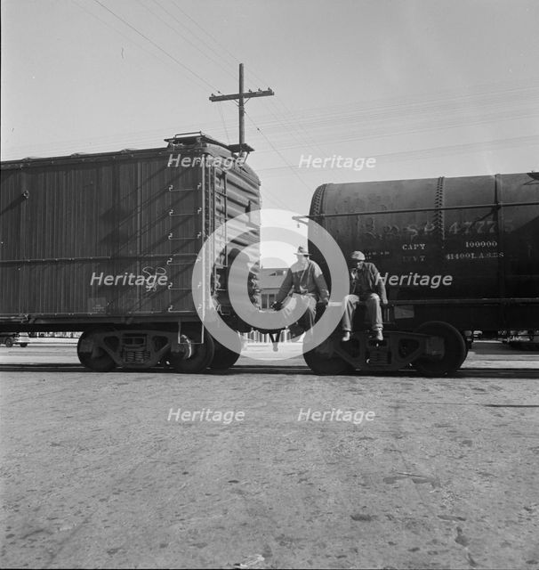 Colored itinerants on oil tank cars passing through Kingsbury, California, 1938. Creator: Dorothea Lange.