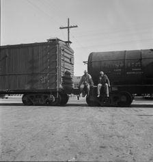 Colored itinerants on oil tank cars passing through Kingsbury, California, 1938. Creator: Dorothea Lange