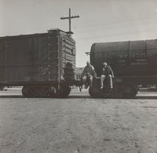 Colored itinerants on oil tank cars passing through Kingsbury, California, 1938. Creators: Farm Security Administration, Dorothea Lange