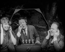 Comedian Harry Tate Sitting With One Female Civilian and One Male Civilian Listening to The..., 1924 Creator: British Pathe Ltd
