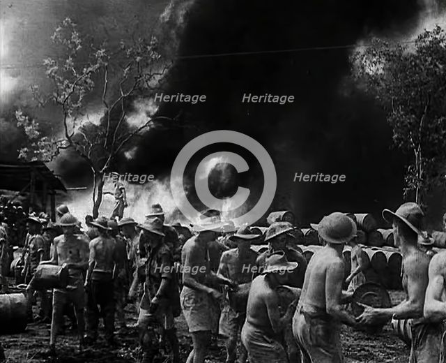 Commonwealth Troops Watching Flames and Smoke Emitting from a Supply Dump, 1941. Creator: British Pathe Ltd.