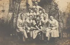 Concert party performers, one in drag, pose for a group portrait, (between 1910 and 1919?). Creator: Unknown