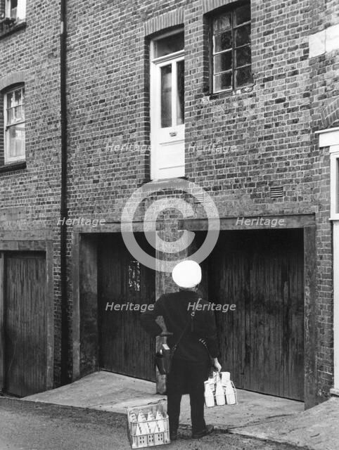 Confused milkman confronted with a doorstep on the first floor, c1955. Creator: Arthur Charles Kirby Ware.