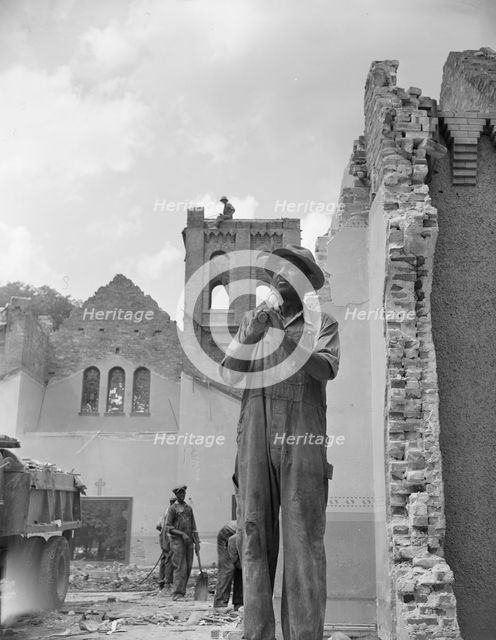 Construction workman wrecking a church on Independence Avenue, Washington, D.C, 1942. Creator: Gordon Parks.