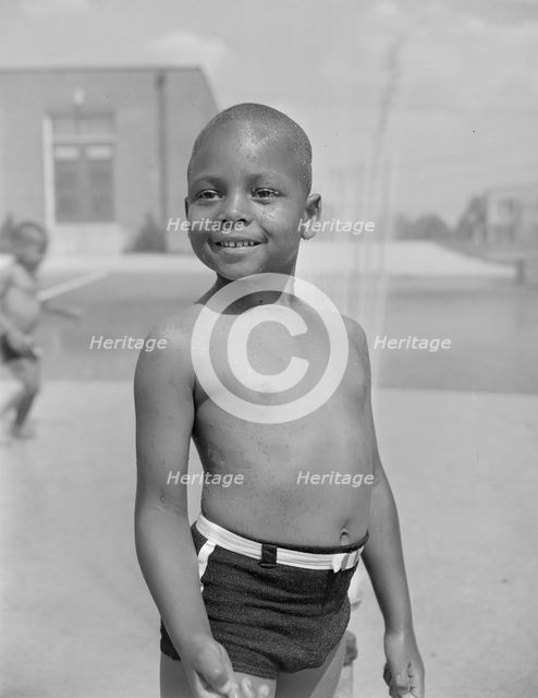 Cooling off under the community sprayer, Frederick Douglass housing project, Anacostia, D.C, 1942. Creator: Gordon Parks.