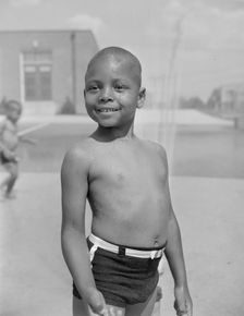 Cooling off under the community sprayer, Frederick Douglass housing project, Anacostia, D.C, 1942. Creator: Gordon Parks