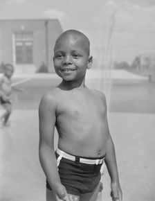 Cooling off under the community sprayer, Frederick Douglass housing project, Anacostia, D.C, 1942. Creator: Gordon Parks