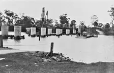 Coomera River Ferry and construction of the road bridge, 1929. Creator: Jack Bain