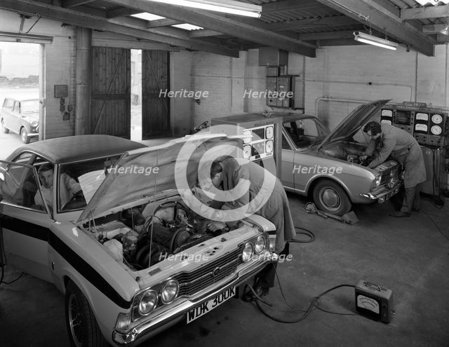 Cortina Mk 2 and Mk3 GT in a garage being serviced/modified, 1972. Creator: Michael Walters.
