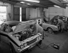 Cortina Mk 2 and Mk3 GT in a garage being serviced/modified, 1972. Creator: Michael Walters
